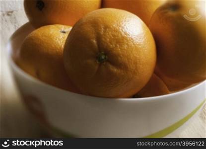 oranges on a platter. oranges on a yellow dish. Wooden background