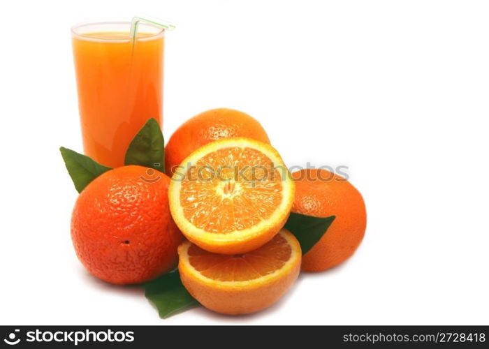 Oranges with green leaves and glass of juice on a white background