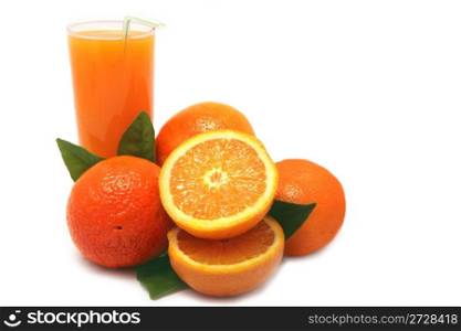Oranges with green leaves and glass of juice on a white background