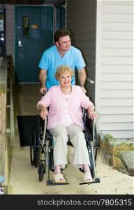 Orderly takes a disabled senior woman out for a walk.