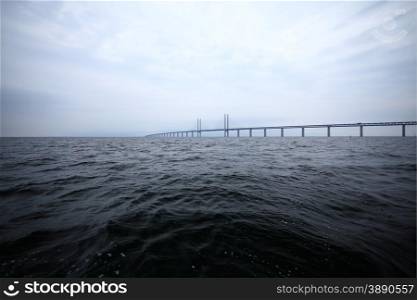 Oresundsbron. The Oresund bridge link between Denmark and Sweden, Europe, Baltic Sea. View from sailboat. Overcast stormy sky.