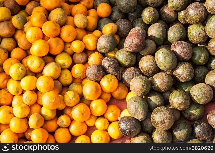 Organic avocado and tangerines fruits for sale at outdoor asian marketplace. Food background