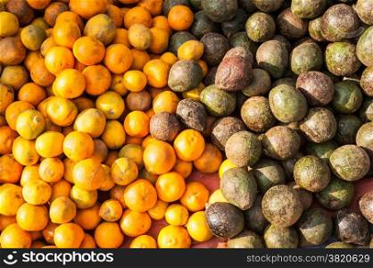 Organic avocado and tangerines fruits for sale at outdoor asian marketplace. Food background