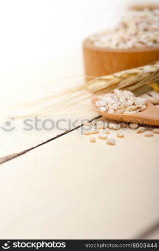 organic barley grains over rustic wood table macro closeup