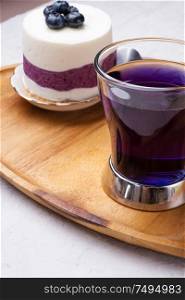organic Butterfly pea, clitoria or Blue pea flower herbal tea. Thai blue tea. served with blueberry cake on wooden tray.