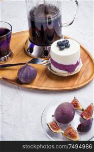 organic Butterfly pea, clitoria or Blue pea flower herbal tea. Thai blue tea. served with lemon, fresh figs and blueberry cake on wooden tray.