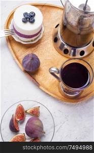 organic Butterfly pea, clitoria or Blue pea flower herbal tea. Thai blue tea. served with lemon, fresh figs and blueberry cake on wooden tray.