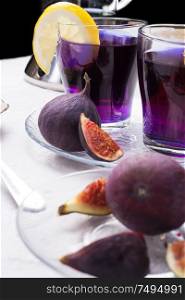 organic Butterfly pea, clitoria or Blue pea flower herbal tea. Thai blue tea. served with lemon and fresh figs. close up