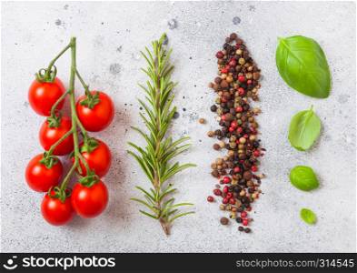 Organic Cherry Sugardrop Tomatoes on the Vine with basil and pepper on white kitchen stone background
