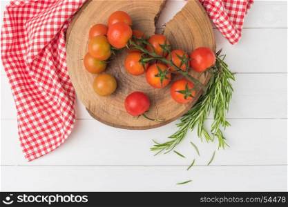 Organic cherry tomatoes with rosemary on rustic wooden table. Top view