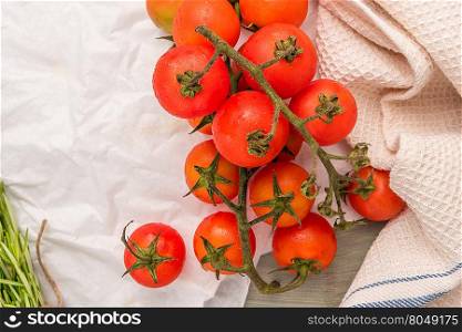 Organic cherry tomatoes with rosemary on wrinkled paper. Top view