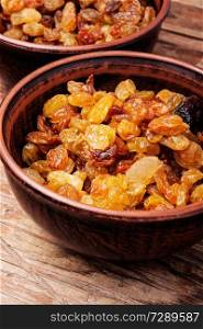 Organic dried golden raisins in a bowl.Delicious dry grapes. Ceramic bowl with raisins