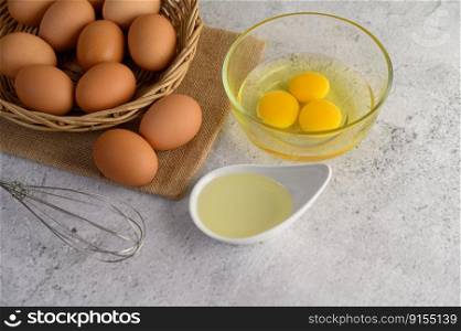 Organic eggs on sack cloth, many eggs on wicker basket and glasses bowl, oil and egg whisk placed on the floor, preparing for cooking food or dessert, copy 


space