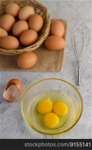 Organic eggs on sack cloth, many eggs on wicker basket and glasses bowl, oil and egg whisk placed on the floor, preparing for cooking food or dessert, copy    space