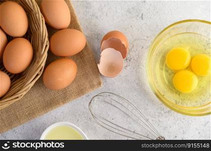 Organic eggs on sack cloth, many eggs on wicker basket and glasses bowl, oil and egg whisk placed on the floor, preparing for cooking food or dessert, copy   space