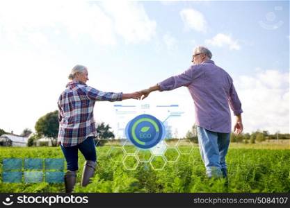 organic farming, agriculture and people concept - happy senior couple holding hands at summer farm. happy senior couple holding hands at summer farm. happy senior couple holding hands at summer farm