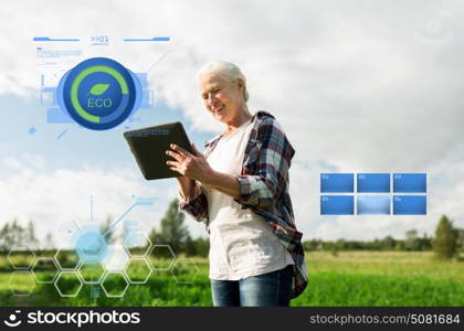 organic farming, agriculture, technology, old age and people concept - happy senior woman with tablet pc computer at county or farm. senior woman with tablet pc computer at county