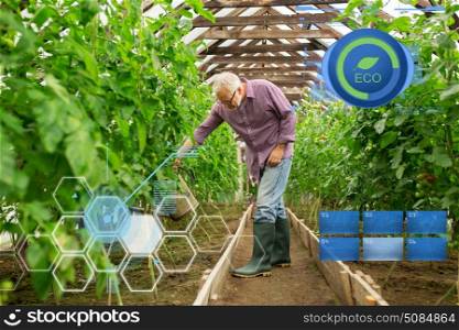 organic farming, gardening, agriculture and people concept - happy senior man with watering can at farm greenhouse. senior man with watering can at farm greenhouse. senior man with watering can at farm greenhouse