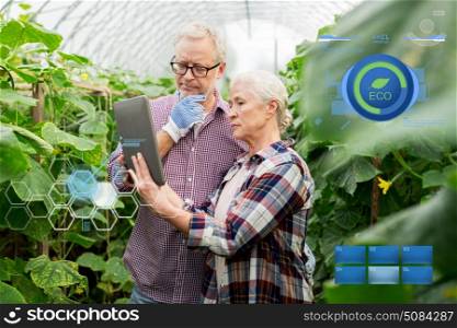 organic farming, gardening, agriculture and people concept - senior couple with tablet pc computer at farm greenhouse. senior couple with tablet pc at farm greenhouse. senior couple with tablet pc at farm greenhouse