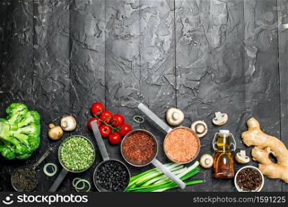Organic food. Different healthy vegetables and fruits with beans. On a black rustic background.. Organic food. Different healthy vegetables and fruits with beans.
