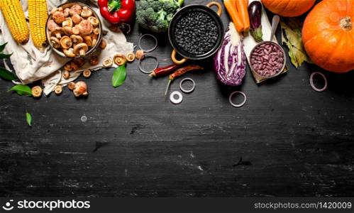Organic food. Fresh vegetables with mushrooms and black beans. On a black chalkboard.. Organic food. Fresh vegetables with mushrooms and black beans.