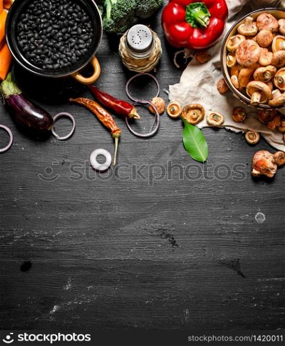 Organic food. Fresh vegetables with mushrooms and black beans. On a black chalkboard.. Organic food. Fresh vegetables with mushrooms and black beans.