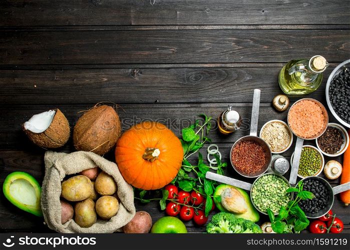 Organic food. Healthy assortment of vegetables and fruits with legumes. On a wooden background.. Organic food. Healthy assortment of vegetables and fruits with legumes.