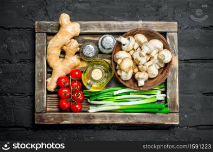 Organic food. Mushrooms with healthy vegetables in a wooden box. On a black rustic background.. Organic food. Mushrooms with healthy vegetables in a wooden box.