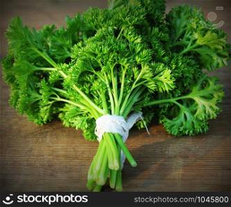 Organic fresh bunch of parsley on a wooden rustic table .. Organic fresh bunch of parsley on a wooden rustic table