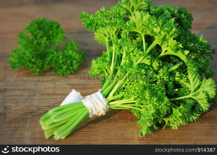 Organic fresh bunch of parsley on a wooden rustic table .. Organic fresh bunch of parsley on a wooden rustic table