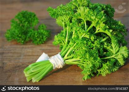 Organic fresh bunch of parsley on a wooden rustic table .. Organic fresh bunch of parsley on a wooden rustic table