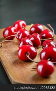 Organic fresh cherries on a wooden cutting board. Fresh cherries on a wooden cutting board