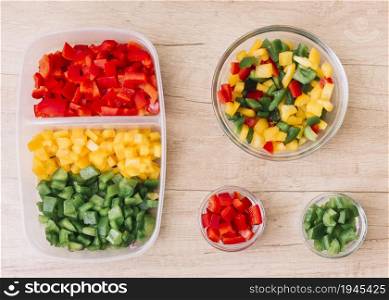 organic fresh chopped red green yellow bell peppers tiffin box glass bowls wooden desk. High resolution photo. organic fresh chopped red green yellow bell peppers tiffin box glass bowls wooden desk. High quality photo
