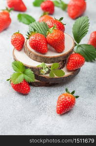 Organic fresh raw strawberries with leaf on timber round boards on light background. Best summer berries.