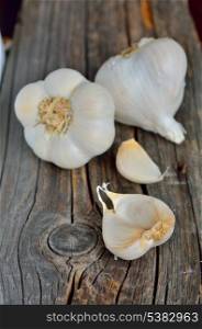 Organic garlic whole and cloves on the old wooden background