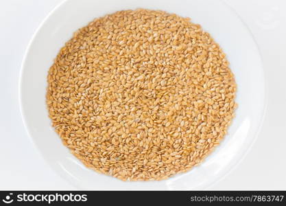 Organic gold flax seeds on a plate, stock photo