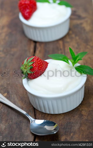 organic Greek yogurt and strawberry on a rustic wood table