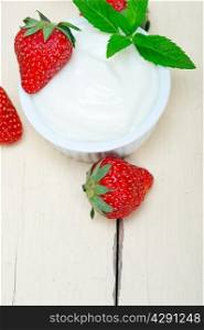 organic Greek yogurt and strawberry over white rustic wood table