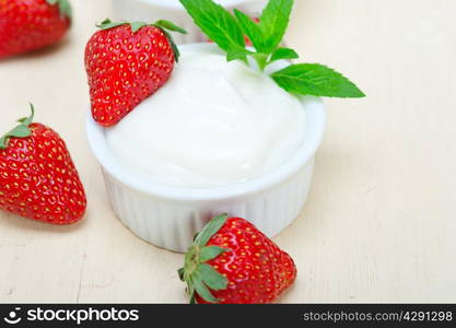 organic Greek yogurt and strawberry over white rustic wood table