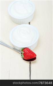 organic Greek yogurt and strawberry over white rustic wood table
