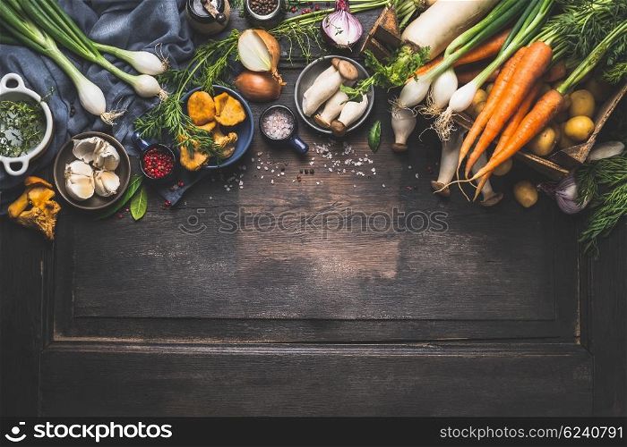 Organic harvest Vegetables from garden and forest mushrooms. Vegetarian ingredients for cooking on dark rustic wooden background, top view, border