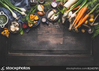 Organic harvest Vegetables from garden and forest mushrooms. Vegetarian ingredients for cooking on dark rustic wooden background, top view, border