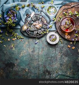Organic herbal tea making with fresh detox herbs and flowers on rustic background, top view, border. Healthy, diet or detox drink