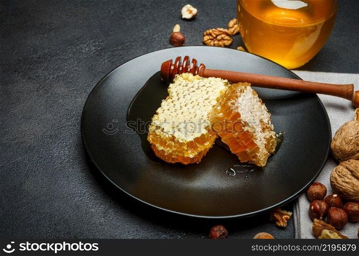Organic Honeycomb with honey on plate. dark concrete background. Honeycomb with honey on plate. dark concrete background