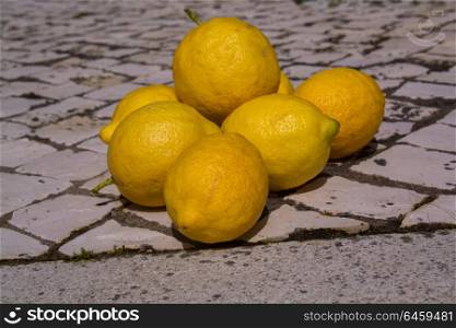 organic lemons laying in traditional portuguese stone pavement