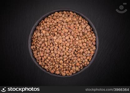 Organic lentils in bowl on a dark background - close up shot
