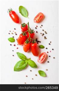 Organic Mini San Marzano Tomatoes on the Vine with basil and pepper on white background
