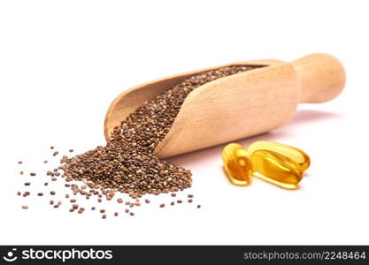 Organic natural chia seeds and wooden scoop close-up and omega pills. High quality photo. Organic natural chia seeds and wooden scoop close-up and omega pills