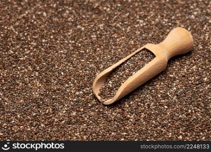 Organic natural chia seeds and wooden scoop close-up. High quality photo. Organic natural chia seeds and wooden scoop close-up