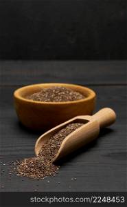 Organic natural chia seeds and wooden scoop close-up on wooden background or table. High quality photo. Organic natural chia seeds and wooden scoop close-up on wooden background or table